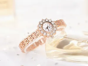 Detail of rose gold watch with sparkling rhinestone sunflower bezel and quartz dial