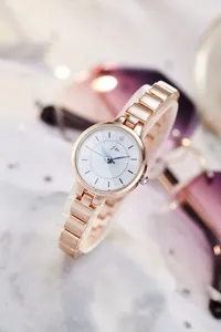 Detail of JW rose gold quartz watch with white textured dial and elegant blue hands