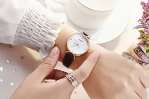 Montre élégante pour femme en or rose avec bracelet en cuir noir et bague scintillante