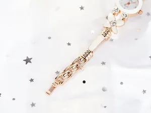 Gros plan du bracelet de montre en or rose avec détail papillon en cristal et maillons