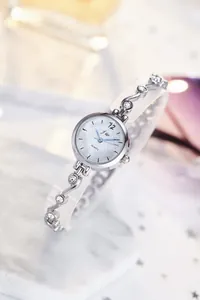 Détail d'une montre argentée pour femme avec bracelet à strass et cadran texturé chic
