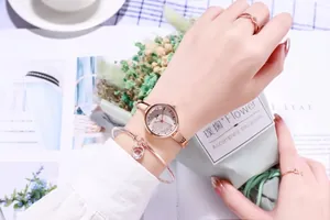 Elegant rose gold watch set with crystal dial, crown bracelet and ring on woman's wrist