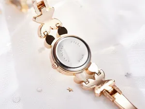 Vue détaillée du bracelet papillon doré et du dos du boîtier en acier inoxydable poli