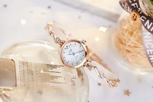 Détails de montre à quartz en or rose avec bracelet en cristal et cadran marbré