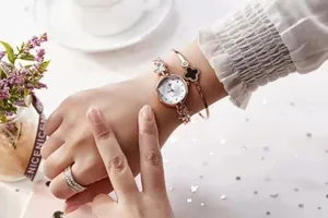 Elegant rose gold star-strap watch with clover bracelet and diamond ring set on wrist