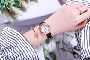 Detail der roségoldenen Katzen-Uhr mit passendem Sternarmband und Ring am Handgelenk