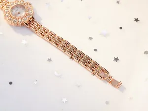 Macro detail of rose gold sunflower watch bezel with diamonds and G&P logo dial