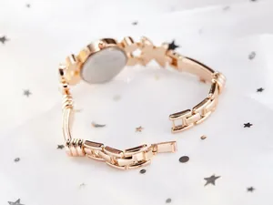 Détail du bracelet papillon en or rose et boucle déployante sur montre pour femme