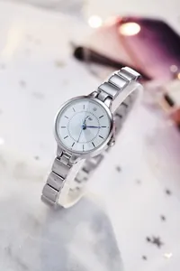 Detail of silver JW quartz watch featuring blue hands and a sparkling diamond accent
