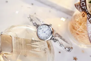 Détail macro d'une montre à quartz argentée pour femme avec bracelet ondulé serti de cristaux