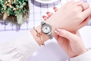 Close-up of elegant silver quartz watch with diamond accents and star charm bracelet