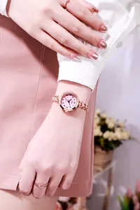 Montre femme chic en or rose avec cadran rose et bracelet gourmette sur le poignet