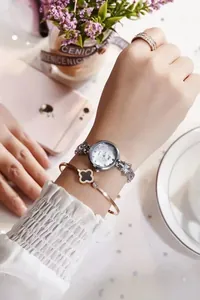 Close-up of elegant silver star strap watch and rose gold clover bracelet set