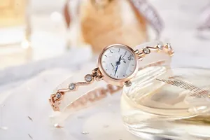 Détail d'une montre en or rose avec cadran à damier et bracelet serti de cristaux brillants