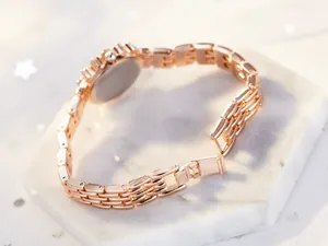 Detail of rose gold metal link bracelet and secure folding clasp on luxury watch