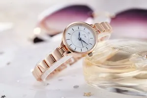Close-up of JW rose gold fashion watch with H-link bracelet and crystal dial accent