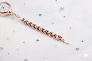 Détail d'une montre à quartz rose doré avec bracelet chaîne raffiné et accents de zircon