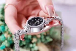 Detailed macro view of elegant silver steel watch featuring a black dial with rhinestones