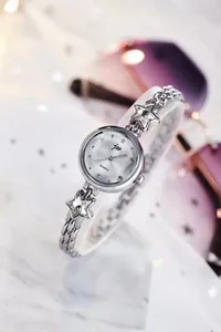 Detail of silver women watch with chain strap star charms and pearl finish dial