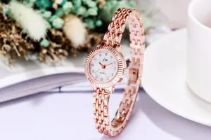 Nahaufnahme der roségoldenen Modeuhr mit Strass-Zifferblatt und elegantem Blumen-Dekor
