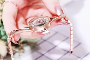 Detail of rose gold watch featuring a faceted crystal glass and sparkling diamond dial