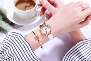 Detailansicht der roségoldenen Katzen-Uhr mit weißem Lederarmband und Sternreif