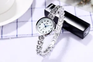 Détail de la montre à quartz argentée avec chiffres arabes et bracelet en métal