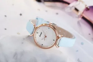 Détail de montre à quartz élégante pour femme avec bracelet bleu clair et boîtier or rose