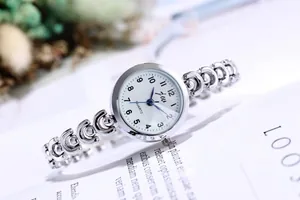 Détail d'une montre à quartz argentée à grands chiffres sur un fond de magazine blanc