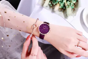 Detail of elegant purple starry dial watch paired with rose gold bracelets and rings