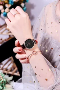 Close-up of a rose gold starry sky watch with a matching knot bracelet and ring set