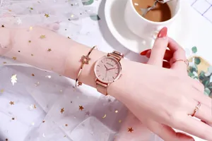 Detalle de reloj de malla oro rosa con esfera rosa estrellada y pulsera de estrella