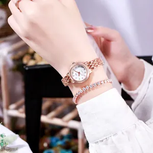 Elegante roségoldene Damenuhr und Strassarmband-Set am Handgelenk für Mode