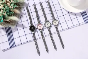 Detail of four colorful GEDI quartz watches with silver metal bands on a stylish table