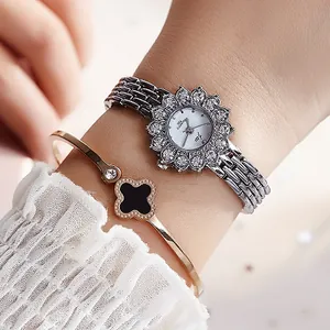 Luxury silver rhinestone watch with sunflower dial and black clover bracelet on wrist