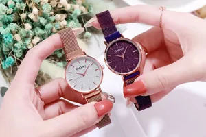 Primer plano de relojes para mujer con esfera estrellada brillante en oro rosa y púrpura