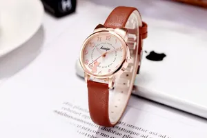 Detailansicht des roségoldenen Katzenohr-Uhrengehäuses und des braunen Lederarmbands der Uhr