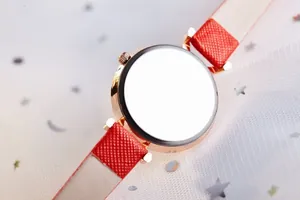 Vue détaillée du dos du boîtier en or rose avec bracelet en cuir rouge sur tissu doux