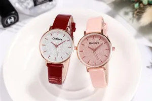 Close-up of red and pink leather strap watches with starry glitter dials and gold casing