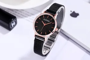 Primer plano de reloj de mujer con esfera de cielo estrellado y correa de malla