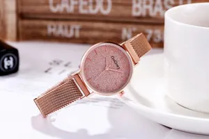 Detalle de reloj elegante en oro rosa con correa de malla y esfera brillante