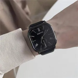 Close-up of a black minimalist square watch featuring Roman numerals on a dark dial