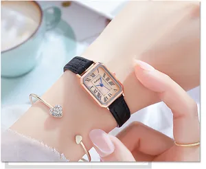 Close-up of rectangular quartz watch with black leather strap on female wrist