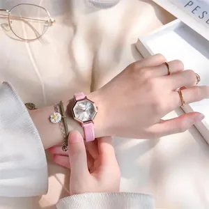 Detail of a pink leather strap watch with rose gold hexagonal case and daisy bracelet