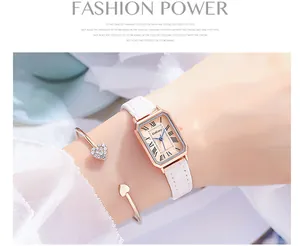 Close-up of elegant rose gold rectangular watch with white leather strap and heart bracelets