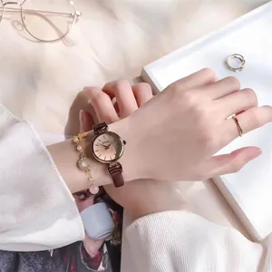 Nahaufnahme einer Vintage-Lederuhr für Damen mit einem goldfarbenen Stern-Mond-Armbandset