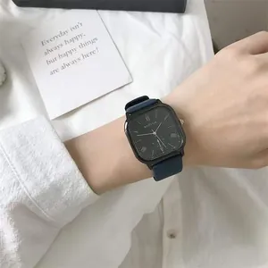 Close-up of minimalist square quartz watch with Roman numerals and blue leather strap