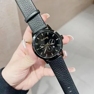 Close-up of black dial watch with gold indices and leather strap on wrist