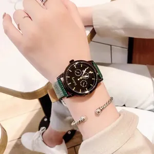Detail of green leather strap watch with gold hands and silver twisted bangle on wrist