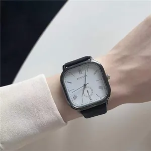Detail of minimalist square quartz watch with white dial and black leather strap